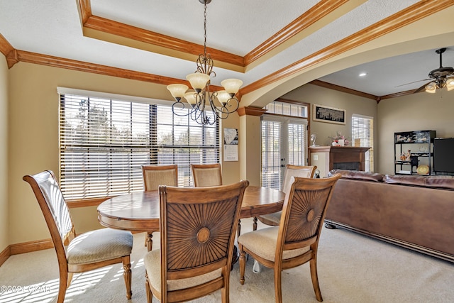 dining room featuring light carpet, ceiling fan with notable chandelier, and ornamental molding