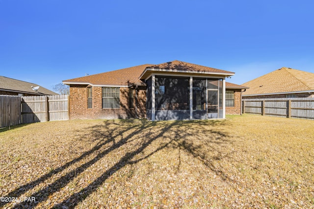 back of house with a sunroom and a lawn