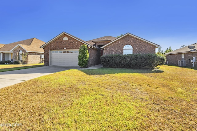 view of front facade featuring central AC, a front yard, and a garage