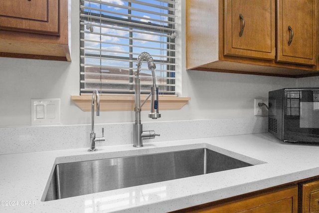 kitchen with light stone counters and sink