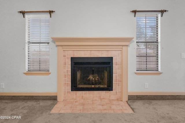 room details featuring a tile fireplace and carpet floors