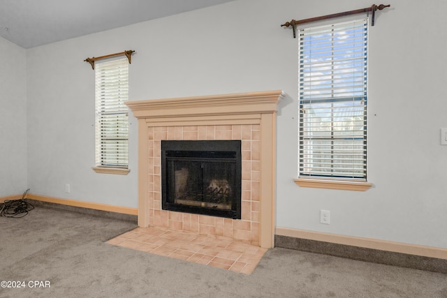 unfurnished living room featuring a fireplace, carpet floors, and plenty of natural light