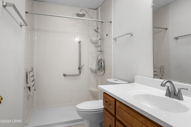 bathroom featuring vanity, toilet, and a tile shower