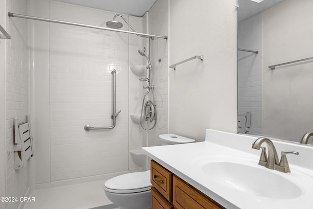 bathroom featuring tiled shower, vanity, and toilet