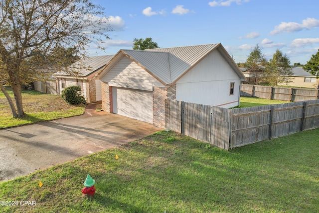 view of side of property featuring a lawn and a garage