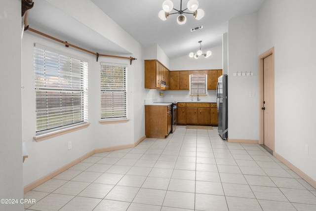 kitchen with a chandelier, stainless steel appliances, a wealth of natural light, and hanging light fixtures