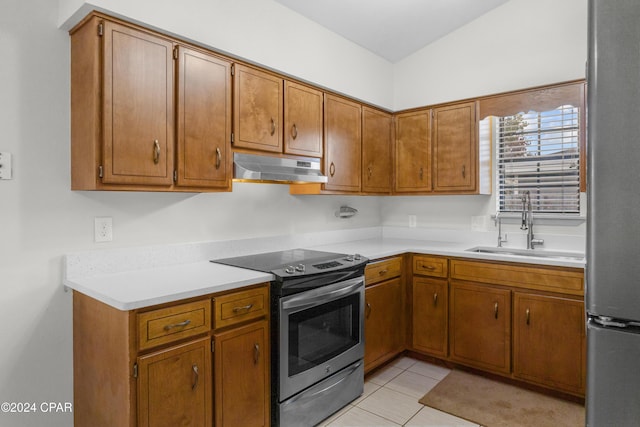 kitchen featuring electric range, sink, light tile patterned floors, and vaulted ceiling