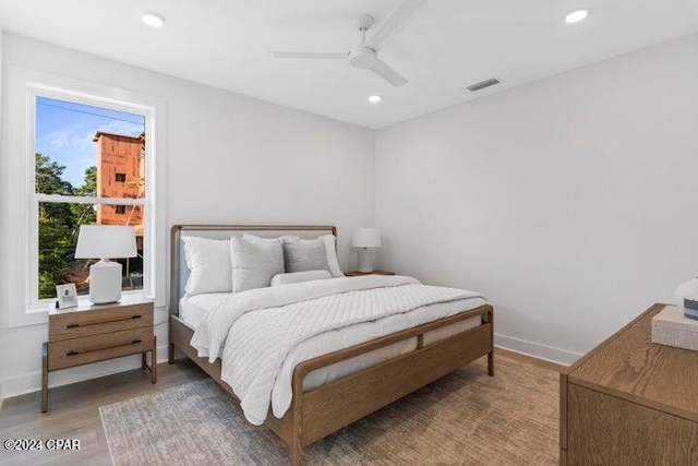 bedroom featuring multiple windows, ceiling fan, and wood-type flooring