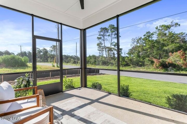 unfurnished sunroom featuring ceiling fan