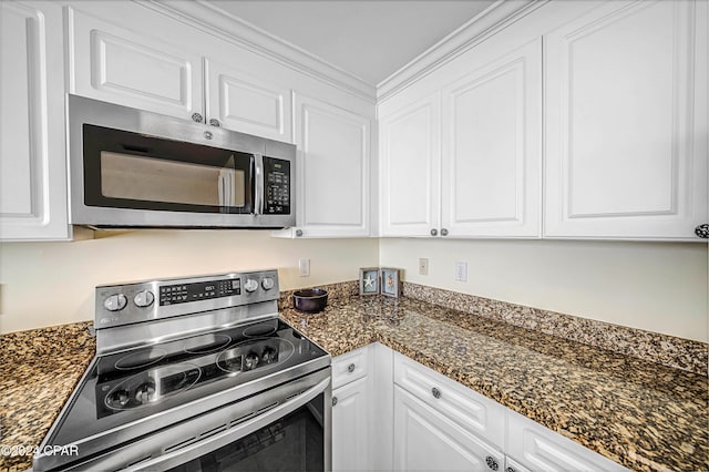 kitchen featuring appliances with stainless steel finishes, white cabinetry, and dark stone counters