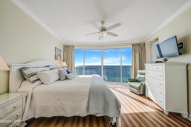 bedroom featuring expansive windows, ornamental molding, access to outside, ceiling fan, and hardwood / wood-style flooring