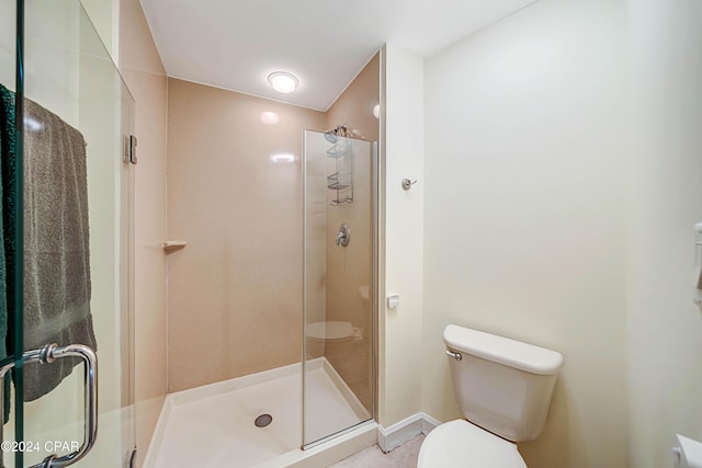 bathroom featuring toilet and an enclosed shower