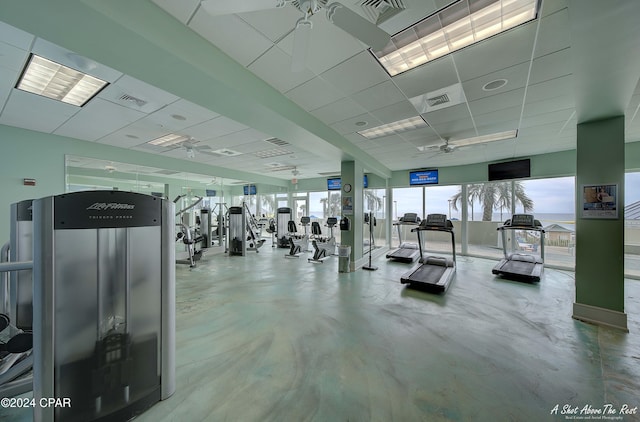 exercise room with a paneled ceiling and ceiling fan