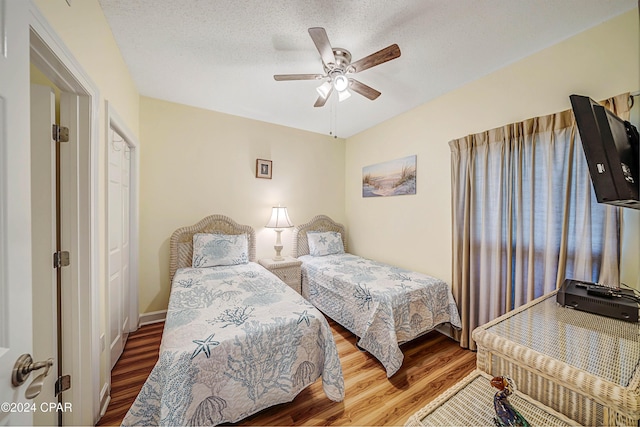 bedroom featuring ceiling fan, a textured ceiling, and hardwood / wood-style flooring