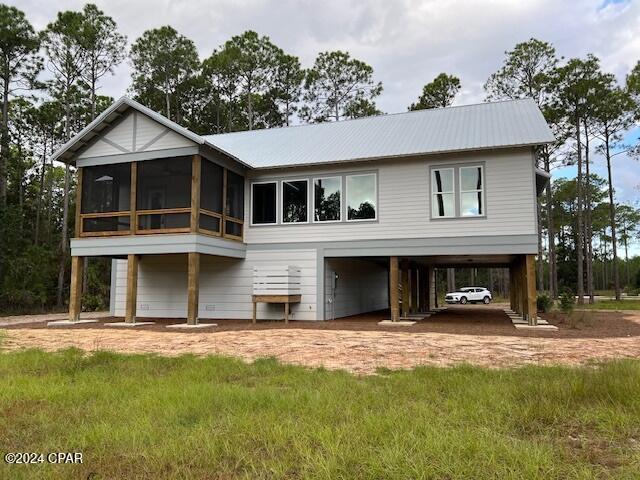 back of house with a carport and a sunroom