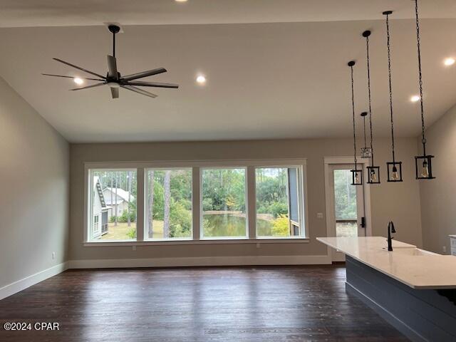 unfurnished living room with dark hardwood / wood-style floors, ceiling fan, lofted ceiling, and sink