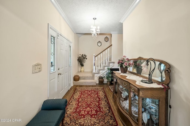 entrance foyer featuring crown molding, a textured ceiling, and an inviting chandelier