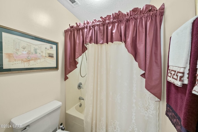 bathroom with shower / bath combo with shower curtain, a textured ceiling, and toilet