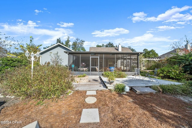 back of property featuring a deck and a sunroom