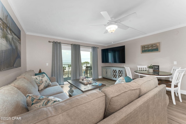 living room with baseboards, light wood-style flooring, a ceiling fan, and ornamental molding