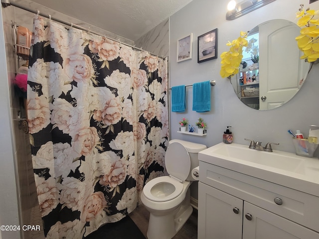 bathroom with vanity, a textured ceiling, toilet, and curtained shower