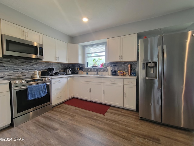 kitchen featuring stainless steel appliances, white cabinetry, and sink