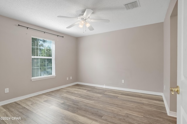 unfurnished room featuring ceiling fan, light hardwood / wood-style flooring, and a textured ceiling