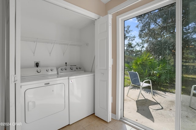 laundry area with washer and clothes dryer and light tile patterned flooring