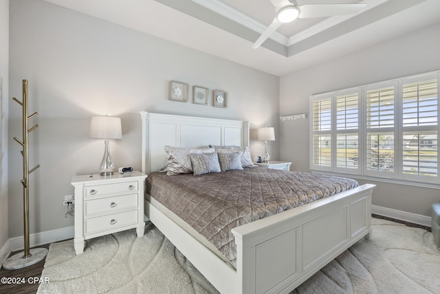 carpeted bedroom with a raised ceiling, ceiling fan, and crown molding