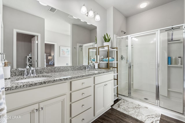 bathroom with vanity, an enclosed shower, and hardwood / wood-style flooring