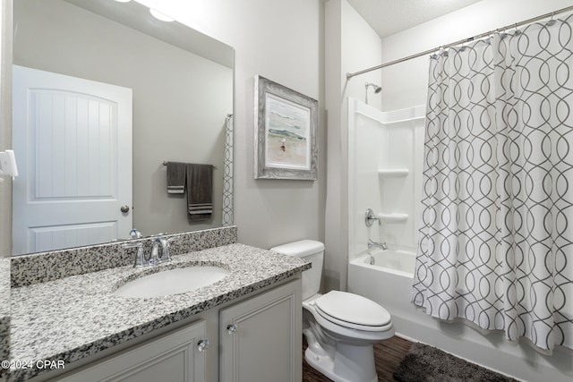 full bathroom featuring hardwood / wood-style floors, vanity, toilet, a textured ceiling, and shower / tub combo