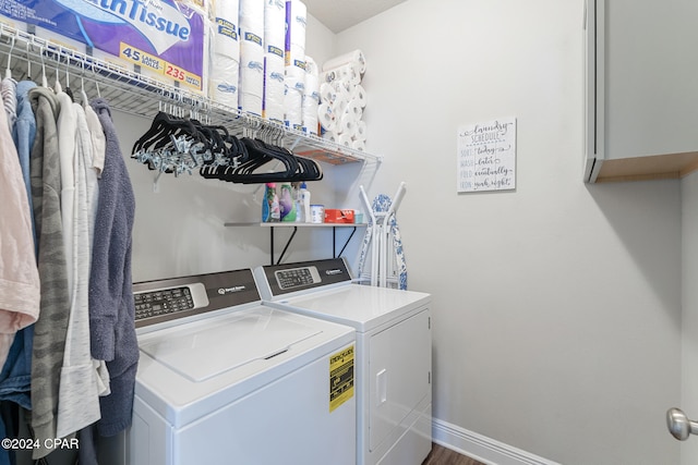 laundry area with cabinets, wood-type flooring, and washing machine and clothes dryer