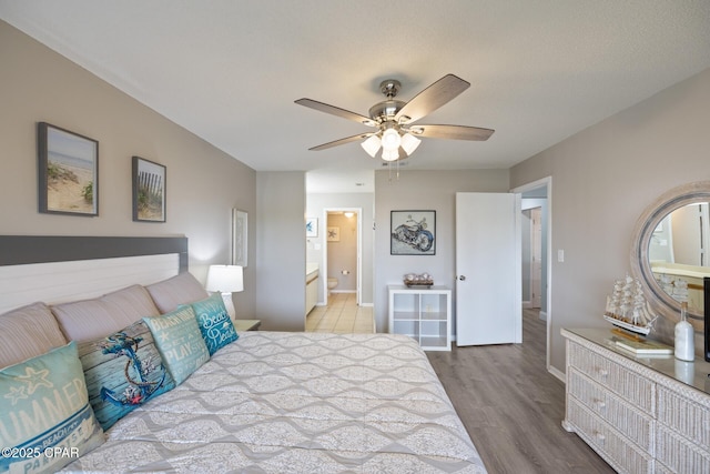 bedroom with ensuite bathroom, ceiling fan, and light hardwood / wood-style floors