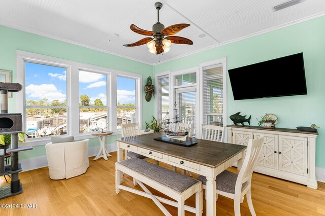 dining space with ceiling fan, light wood-type flooring, and ornamental molding