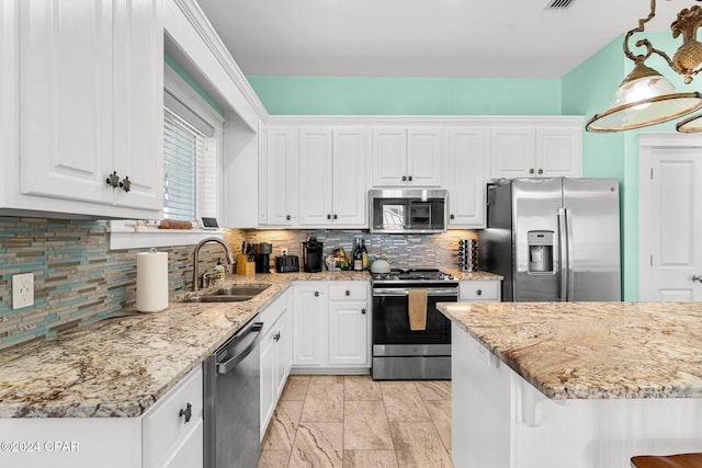 kitchen featuring white cabinets, sink, decorative backsplash, decorative light fixtures, and stainless steel appliances