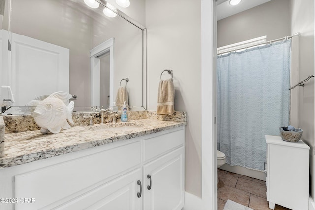 bathroom featuring tile patterned flooring, vanity, and toilet