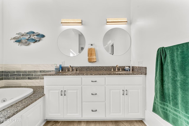 bathroom with hardwood / wood-style floors, vanity, and a tub