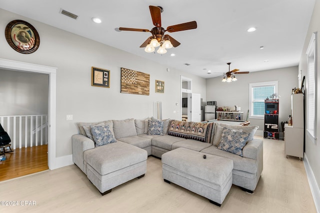 living room featuring ceiling fan and light hardwood / wood-style flooring