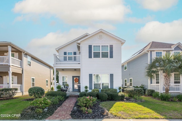 view of front of house featuring a front lawn, a porch, and a balcony