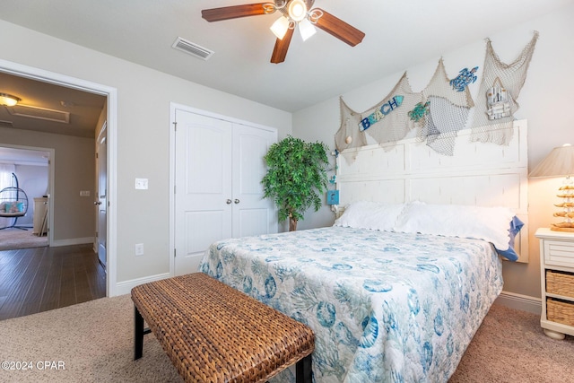 carpeted bedroom featuring a closet, visible vents, attic access, ceiling fan, and baseboards