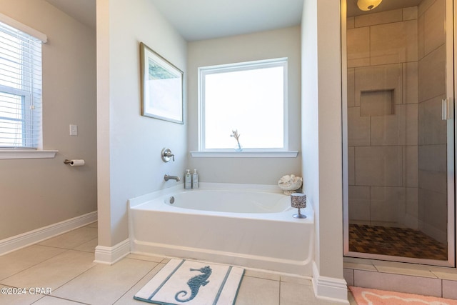 full bathroom featuring tile patterned flooring, baseboards, a bath, and a shower stall