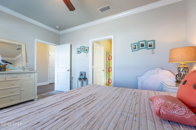 bedroom with a ceiling fan, visible vents, crown molding, and wood finished floors