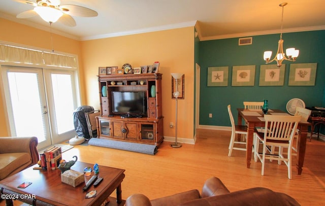 living room with french doors, wood-type flooring, ceiling fan with notable chandelier, and ornamental molding