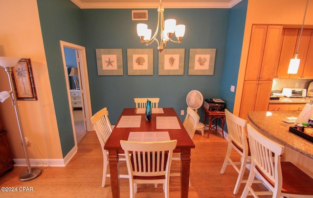 dining area featuring a chandelier, light hardwood / wood-style floors, and ornamental molding