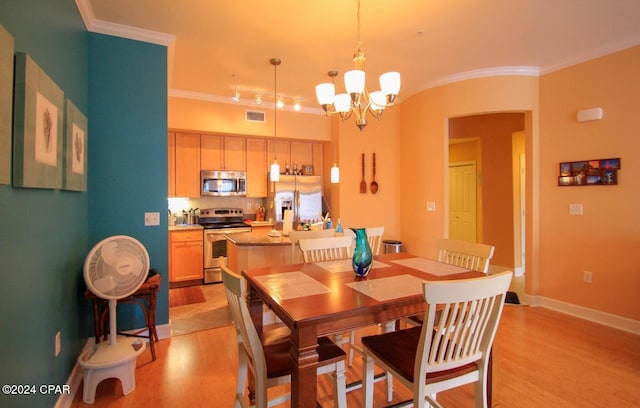 dining space featuring light hardwood / wood-style flooring, an inviting chandelier, and ornamental molding