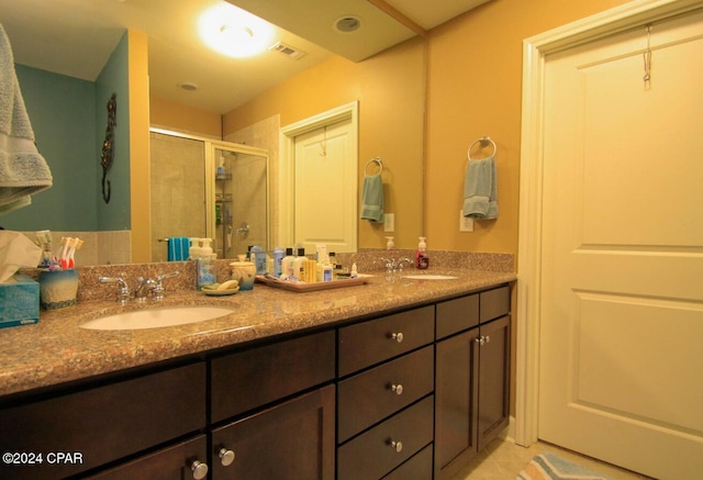 bathroom with tile patterned flooring, vanity, and a shower with door