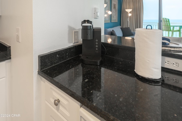 interior details featuring white cabinets and dark stone counters