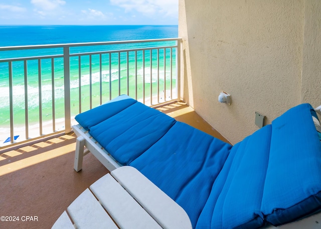 balcony featuring a beach view and a water view