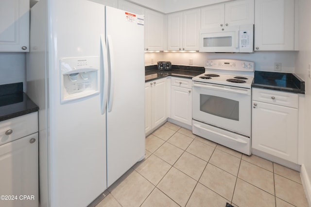 kitchen with light tile patterned flooring, white appliances, and white cabinetry