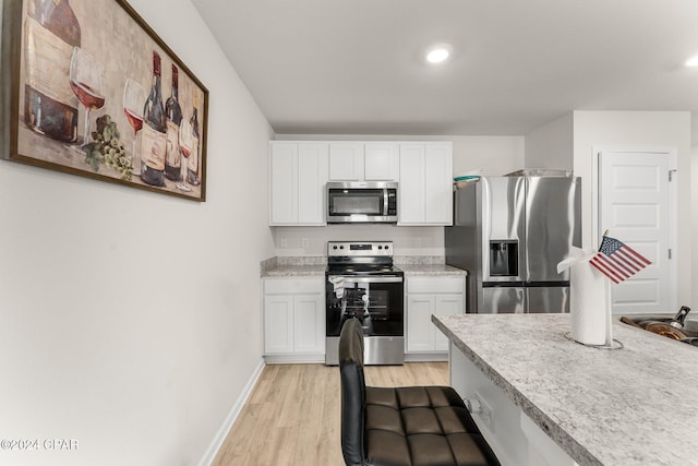 kitchen featuring white cabinets, appliances with stainless steel finishes, and light hardwood / wood-style floors